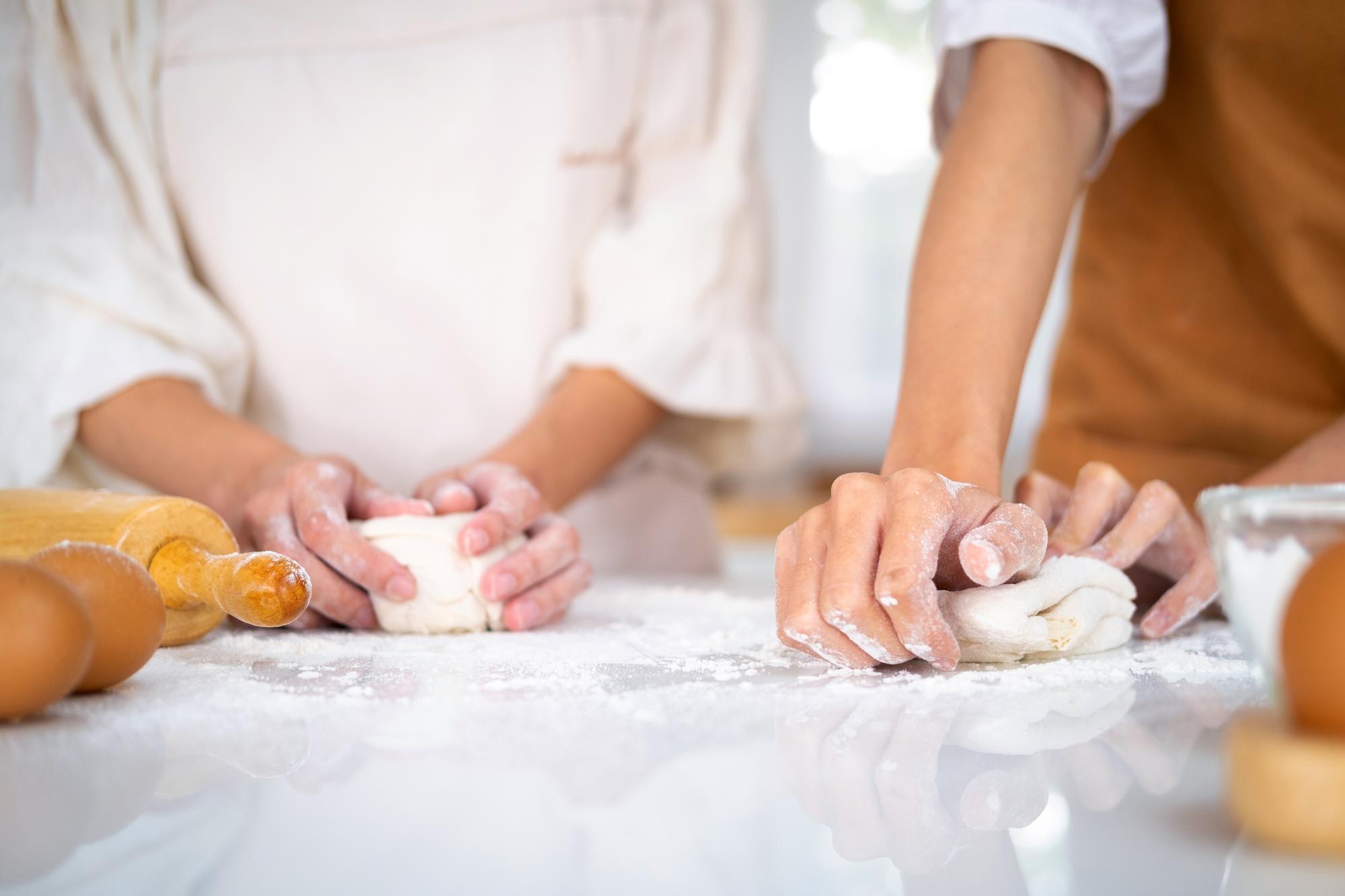 hands folding delicate pastry in natural light