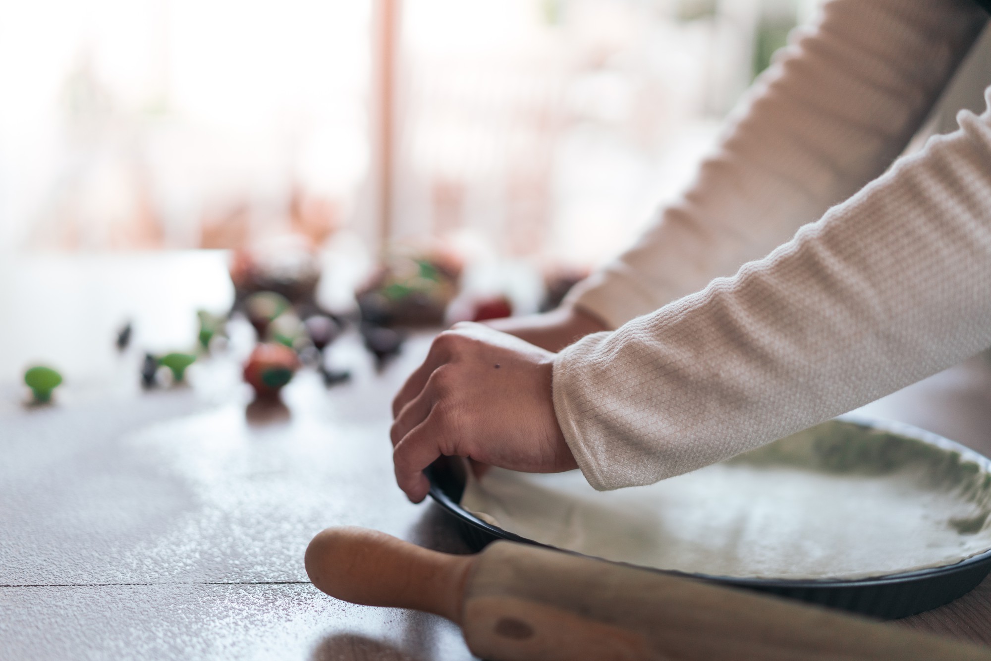 hands plating a simple composed dish on neutral table
